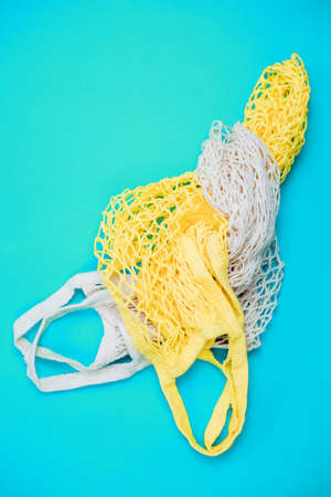 The concept of zero waste without plastic. Cotton reusable mesh shopping bag on a blue background.Handmade work. Taking care of nature.の写真素材