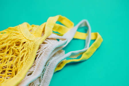 The concept of zero waste without plastic. Cotton reusable mesh shopping bag on a blue background.Handmade work. Taking care of nature.の写真素材