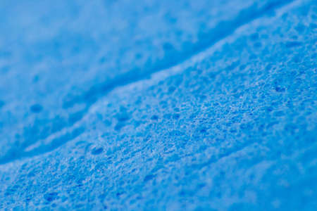 A blue sponge for cleaning surfaces in the kitchen and bathroom. The texture of the fibers and holes.の写真素材