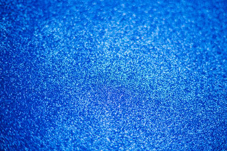 Blurry shimmering background of blue sequins. Silver glitter, light abstract bokeh texture. Drawing design. Sparkling wallpaper for Christmas. Party time.の写真素材