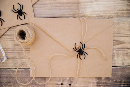 A kraft paper envelope and felt skeletons, spiders, around on a wooden background. Halloween decor. Handmade holiday decorations.の写真素材
