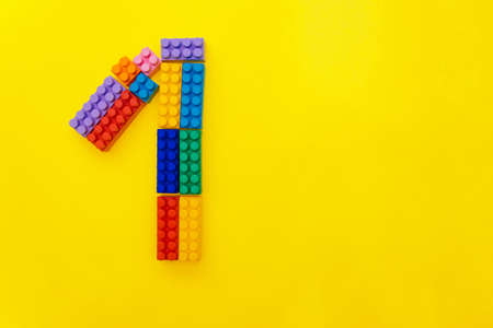 Figure one of the children's multi-colored constructor on a yellow background. Empty space for the...