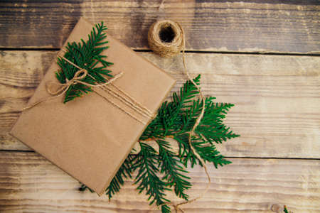 Boxes packed with kraft paper and natural twine on a wooden background. Delivery service.Eco-friendly material. Handmade art craft. The concept of Christmas and New Year.の写真素材