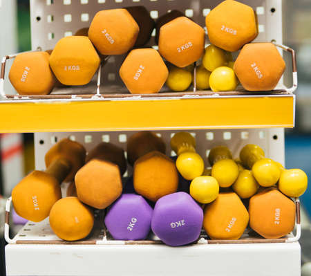 A rack with colored metal dumbbells in the gym or fitness club. Exercise and a healthy lifestyle. Strength exercises.の写真素材