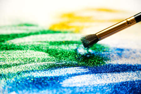 Abstract texture of small sequins. Brilliant festive background. Multicolored sequins and a tassel on a white background.の写真素材