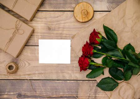 Top view, invitation or postcard empty space for text. Festive atmosphere, red roses, on a wooden background.の写真素材