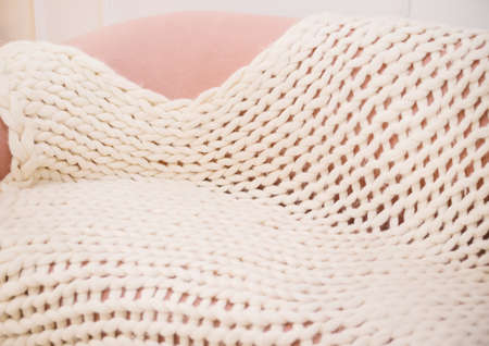 Large handmade merino wool blanket, super thick yarn, fashionable concept. Close-up of a knitted...