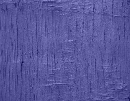 Demonstrating the fashionable color of 2022 - purple. A background of purple, peeling paint on an old wooden wall. Uneven texture of the boards.の写真素材