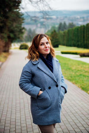 A young woman is walking in the park. Narrow sidewalk and trees. outdoor recreation.の写真素材