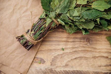 A dry birch broom lies on a wooden background. Accessories for baths and saunas. spa treatments. Natural, eco-friendly materials.の写真素材