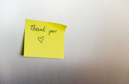 Yellow square stickers are glued to the refrigerator. Sheets for recording information. Reminders, the inscription thank you. Empty space for the text.の写真素材