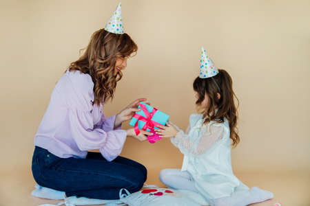 Charming cheerful family sitting on the floor and having fun during the festive time. birthday...