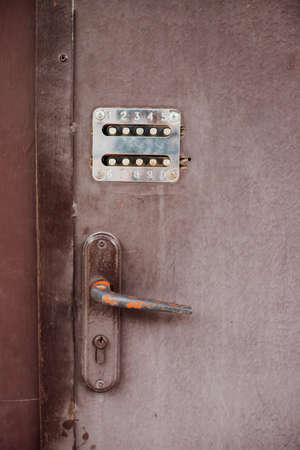 The old combination lock. Entering or leaving the house. An old metal door. metal door.の写真素材