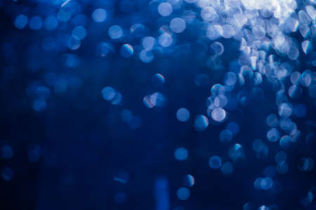 abstract background. Bokeh of sun glare. texture. The light from sunset or dawn passes through the glass. Tinted photo in blue.の写真素材
