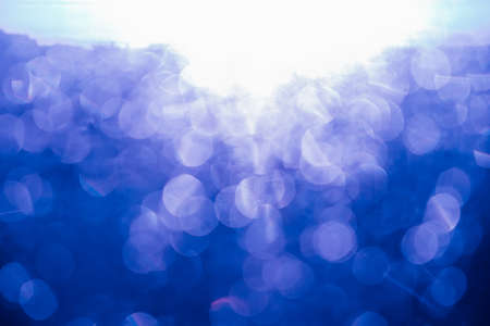 abstract background. Bokeh of sun glare. texture. The light from sunset or dawn passes through the glass. Tinted photo in blue.の写真素材