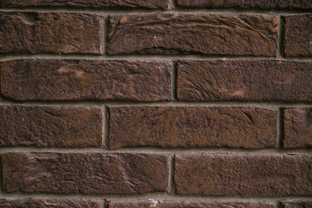 Dark brown brick wall. Empty space for the text. Abstract background and texture.