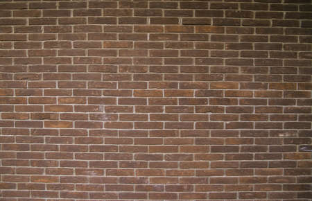 Dark brown brick wall. Empty space for the text. Abstract background and texture.