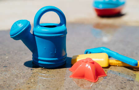 A set of children's toys for playing in the sandbox. Colored rake, shovel, watering can made of...