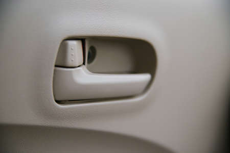 Beige interior of the car. Door handle from the inside close-up. An old style pen. blocking the exit.の写真素材