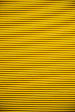 Abstract background made of corrugated paper for yellow application. Space for text. texture. horizontal stripes.の写真素材