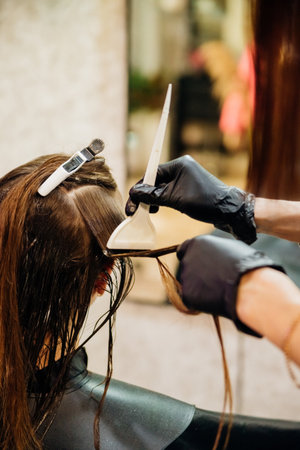 Close-up of a woman's head in the process of hair coloring in a beauty salon. Close-up of a woman's...