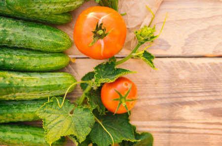 Fresh vegetables on a wooden background. Empty space for the text. Cucumbers, tomatoes, garlic, dill. Top view.の写真素材