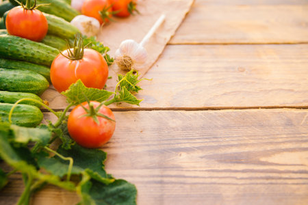 Fresh vegetables on a wooden background. Empty space for the text. Cucumbers, tomatoes, garlic, dill. Top view.の写真素材