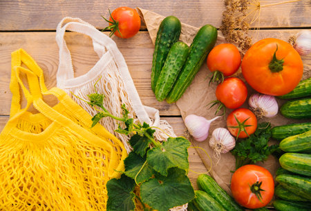 Reusable shopping bag, string bag made of recycled materials, on a wooden table among fresh vegetables. No plastic. Eco-friendly lifestyle.の写真素材