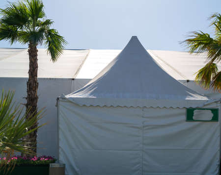 A huge tent in a grass field under a sunny skyの写真素材