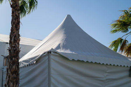 A huge tent in a grass field under a sunny skyの写真素材