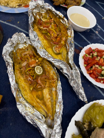 Grilled whole fish, potatoes, lemon, and garlicの写真素材