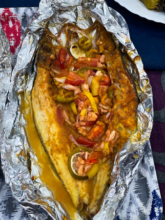 Grilled whole fish, potatoes, lemon, and garlicの写真素材