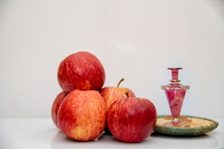 Red apples and perfume bottle on a white background. Shallow depth of fieldの写真素材