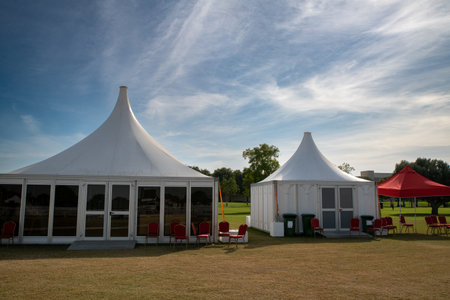 Wedding tent with red chairs and a blue sky in the backgroundの写真素材