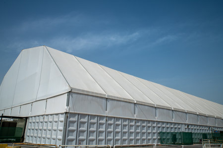 Greenhouse roof with blue sky and white clouds in the background.の写真素材