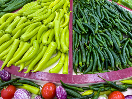Green chilli and other vegetables on display at a farmers market.の写真素材