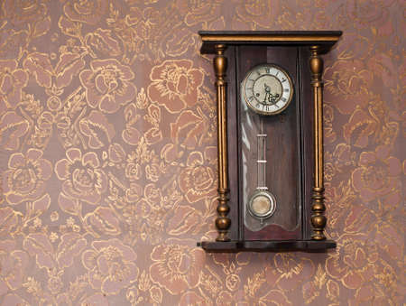 Antique clock on the wall with textured wallpaperの写真素材