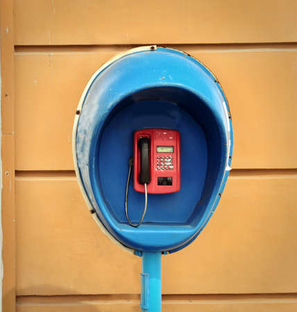 The blue pay phone is fixed on a wallの写真素材
