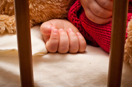 little baby is sleeping in his bed with his toyの写真素材