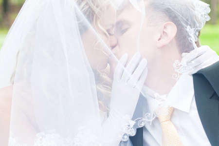 Happy young husband and wife are kissingの写真素材