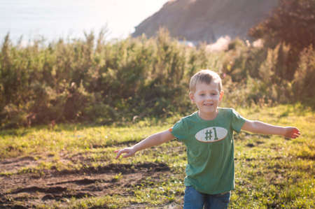 Cheerful child running in the park on sunny summer day