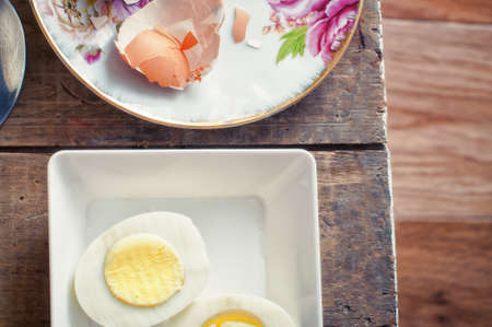 Hard boiled eggs and eggshell on rustic wooden table