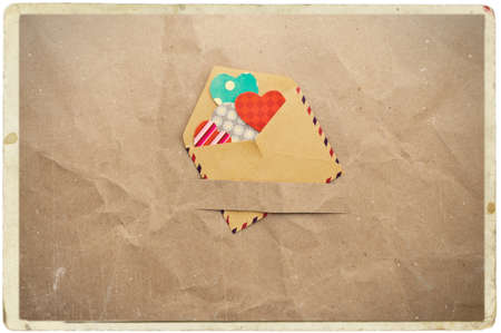 envelope with hearts on old vintage crumpled paper backgroundの写真素材