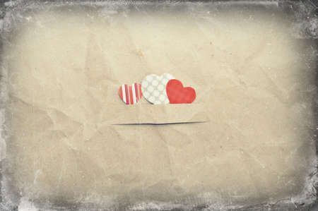 three hearts on old vintage crumpled paper backgroundの写真素材