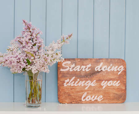 Vintage poster with inspiring words and romantic gentle bunch of lilac on the tableの写真素材