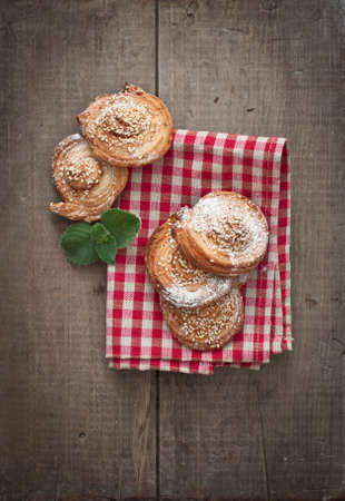 Homemade bakery, puff cookies with sesame seeds on plate, english tea and tender beautiful flowers
