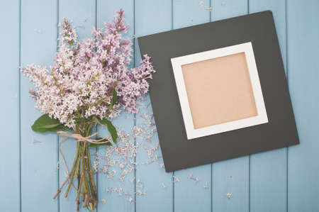 Black wooden vintage picture frame and  summer blooming bouquet of lilacの写真素材
