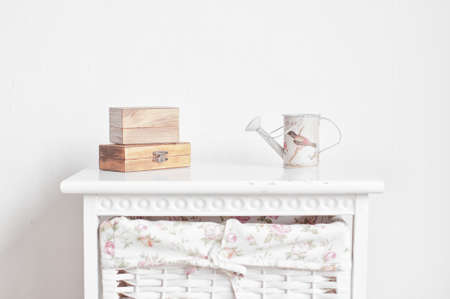 Two wooden boxes and vintage watering can on the white bedside tableの写真素材