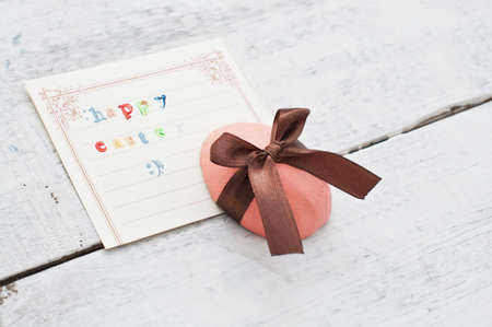 easter egg decorated with ribbon and card on wooden background