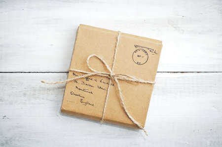 Gift package wrapped with paper and rope on vintage wooden backgroundの写真素材